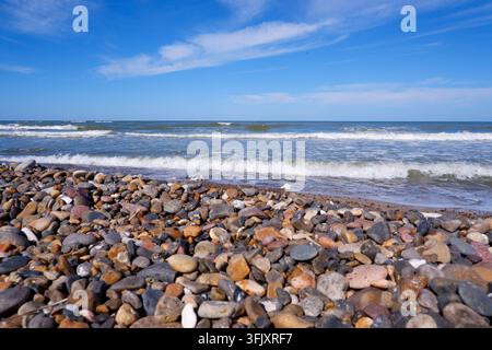 Steinküste der Nordsee aus kleinen Kopfsteinpflastersteinen. Steine am Strand. Kieselsteine an der Küste. Stockfoto