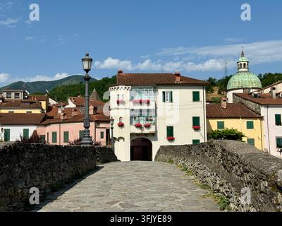 Blick auf das historische Pontremoli in Lunigiana, Toskana, Italien, fotografiert von einer Steinbrücke mit traditionellen farbenfrohen Gebäuden und grünen Fensterläden Stockfoto