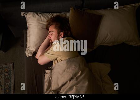 Mann schläft friedlich im Bett während der Nachtruhe Stockfoto