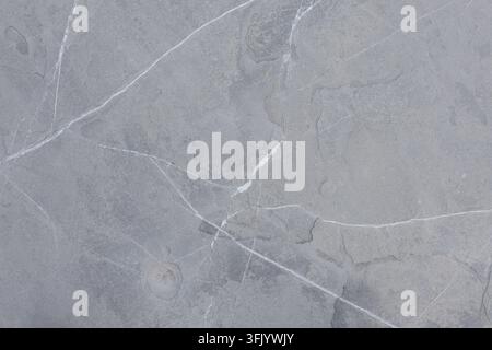 Graue Schieferstein-Bodenstruktur mit Sneaker-Detail Stockfoto