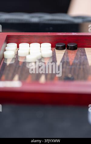 Nahaufnahme eines klassischen Backgammonbretts mit weißen und schwarzen Steinen, perfekt für Freizeit- und Strategiespielkonzepte. Stockfoto