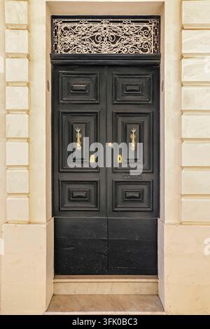 Eine alte schwarze Holztür in mediterraner Umgebung in einer historischen Stadt in Italien Stockfoto
