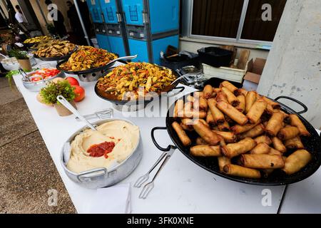 Catering-Buffet-Tisch mit Frühlingsrollen, Hummus und warmen Gerichten Stockfoto