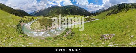 Alpine Wildnis und Bergbach in den Kitzbühel-Alpen, malerischer Luftbildblick auf einen Fluss, der sich durch ein grünes Tal in den Hohen Tauern windet Stockfoto