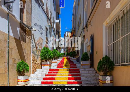 Calpe, Spanien, 30. Mai 2025: Spanische Treppe Spanische Flaggen-Treppen Treppenhaus Calle Puchalt enge Straße mit typischen Gebäuden in der historischen Stadt Calpe Stockfoto