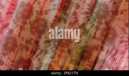 Eine Nahaufnahme eines Batikstoffs mit kreisförmigen Sternstrahlenmustern vor einem Hintergrund aus diagonalen rosa und orangefarbenen Streifen. Stockfoto