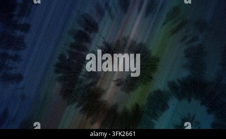 Ein dunkler, stimmungsvoller Textilhintergrund mit einem Batik-Spiralmuster, verstärkt durch subtile Streifen aus grünem, blauem und orangefarbenem Licht auf der Stoffoberfläche. Stockfoto