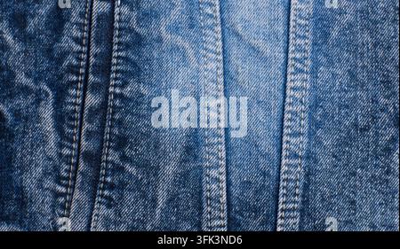 blaue Denimjacke mit vertikalen Nähten, verwaschenem Indigo-Stoff, Stichdetails und einem Metallknopf Stockfoto