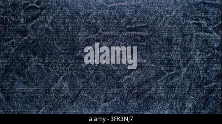 Dunkelblaue Denim-Textiloberfläche mit subtilen abgenutzten Details und grober Stoffstruktur, ideal als Mode- oder Materialhintergrund. Stockfoto
