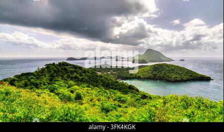 Hochwinkel-Panorama über üppige grüne Hügel, türkisblaue Meereswellen und benachbarte Inseln in Terre-de-Bas, les Saintes, Guadeloupe. Stockfoto