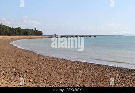 Ein weitläufiger Blick auf die geschwungene felsige Küstenlinie und das ruhige türkisfarbene Wasser am Clairview-Strand in Queensland, Australien Stockfoto