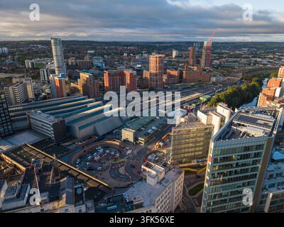 Luftbild der Leeds Railway Station, der Wagenschuppen, der Gleise, des Flusses Aire und der südlichen Stadtsilhouette, die im frühen Morgenlicht badet. Stockfoto