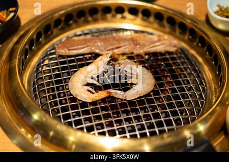 Gegrillte Garnelen und Fleisch auf einem koreanischen BBQ-Grill Stockfoto