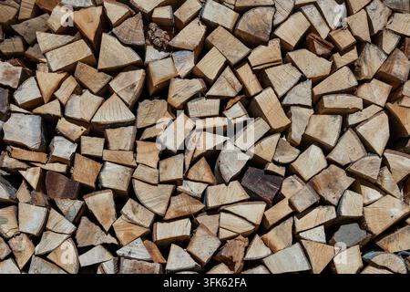 Stapel Feuerholz, abstrakter Holz-Hintergrund. Trockenes gehacktes Feuerholz bereit für den Winter, Nahaufnahme Stockfoto