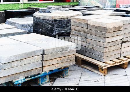 Betonpflasterplatten, gestapelt auf Holzpaletten für Landschaftsgestaltung und Gehwegbau Stockfoto