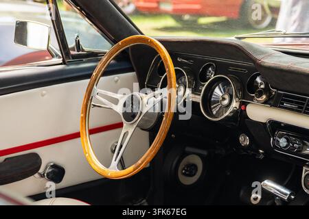 Vintage-Auto-Innenraum mit Holzlenkrad, klassischem Armaturenbrett und Retro-Instrumenten Stockfoto