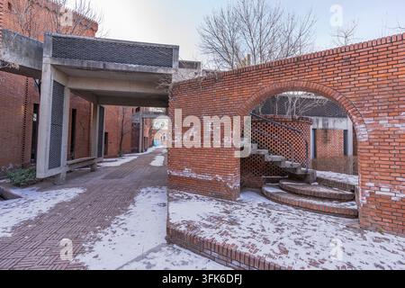 Rotziegelbögen und Betonweg mit Restschnee im Red Brick Art Museum, Peking Stockfoto