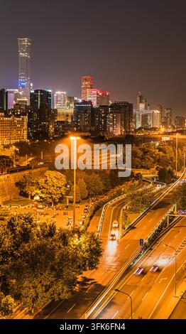 Vertikale Aufnahme der CBD-Skyline bei Nacht, gesehen vom Park der Ming-Stadtmauer-Ruinen in Peking Stockfoto