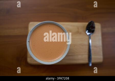 Traditioneller orangefarbener thailändischer Eistee in einer klaren Tasse in einem Einkaufszentrum in Koh Samui, Thailand, am 24. Februar 2025 Stockfoto