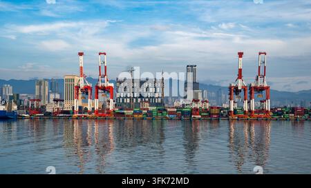 Blick auf den Containerterminal der Cebu Port Authority mit roten Kränen und gestapelten Schiffscontainern entlang der Uferpromenade in Cebu City, Zentralvisayas, Stockfoto