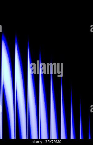 Abstrakte Langzeitbelichtungs-Fotografie von leuchtenden blauen und weißen Lichtspitzen oder Schallwellen, die auf einem schwarzen Hintergrund aufsteigen. Konzept von Audio-Equal Stockfoto