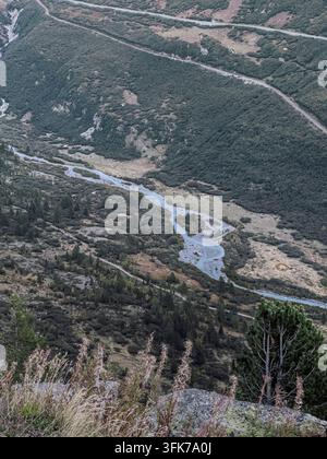 Erhöhte Ansicht eines alpinen Flusssystems nahe dem Grimselpass, Schweiz, das durch ein abgelegenes Tal in den Schweizer Alpen fließt. Stockfoto