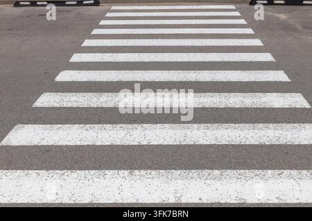 Zebrastreifen für Fußgänger auf Asphaltstraße gemalt Stockfoto