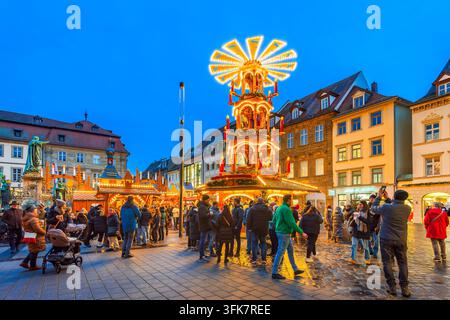 Bamberg, Deutschland - 28. November 2025. Menge auf dem Bamberg Weihnachtsmarkt mit riesiger beleuchteter Holzpyramide Stockfoto