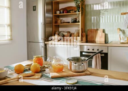 Frische hausgemachte Orangenmarmelade in Gläsern auf dem Küchentisch Stockfoto