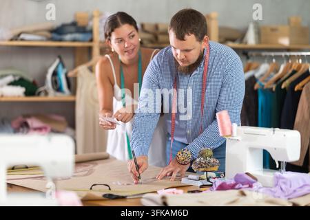Modedesigner entwickeln Kleidungsmuster auf Papier im Studio Stockfoto