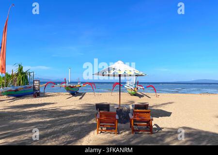 Strandliegen und Sonnenschirme am sandigen Ufer von Jerman Beach, Bali, Indonesien, 19. April 2026. Stockfoto