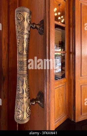 Verzierte geschnitzte Türgriffe an einer traditionellen Holztür eines Hotels in Solo, Zentraljava, Indonesien. 10. Mai 2026. Stockfoto