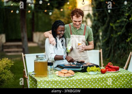 Genießt ein sonniges Grillfest mit Freunden in einer schönen Hinterhofumgebung Stockfoto