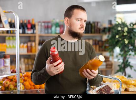 Mann, der Saft im Laden auswählt Stockfoto