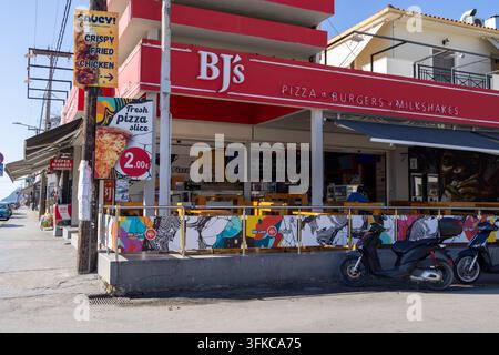 Laganas, Zakynthos Griechenland, 1. September 2026: Fassade von BJ's Restaurant an einer griechischen Resortstraße, die Pizza, Burger, Milchshakes und frittiertes Hühnerfleisch anbietet Stockfoto