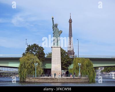 PARIS, FRANKREICH-23. AUGUST 2026: Freiheitsstatue, gesehen von der Seine in Paris, Frankreich, an einem Sommertag mit dem Eiffelturm im Hintergrund Stockfoto