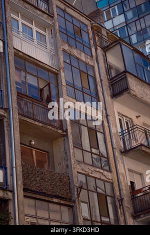 Detaillierte Ansicht von kontrastierenden Wohnfassaden mit Balkonen, geschlossenen Balkonen und großen Fenstern in Belgrad, Serbien. Stockfoto