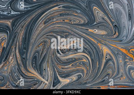 Detaillierte Flüssigkeitstextur aus Farbe, die graue und schwarze Wirbel mit feurigen orangefarbenen marmorierten Akzenten vermischt Stockfoto