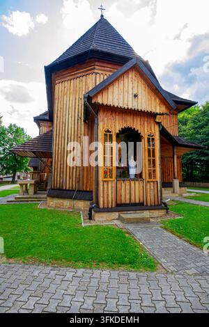Eine hölzerne Kapelle mit einem Kreuz aus dem 18. Jahrhundert ist an der Nordwand des Chors der Pfarrkirche St. Jakob des Älteren und St. Catherina angebracht. Stockfoto