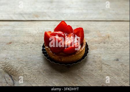 Erdbeertarte mit glasiertem Obst auf rustikalem Holztisch Stockfoto