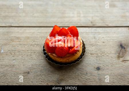 Erdbeertarte mit glasiertem Obst auf rustikalem Holztisch Stockfoto