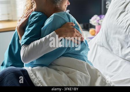 Krankenschwester umarmt einen Seniorpatienten im Krankenhausbett Stockfoto