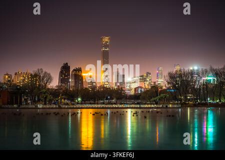 Nachtansicht des Beijing CBD CITIC Tower, der sich auf einem See spiegelt, städtische Stadtlandschaft bei Nacht Stockfoto