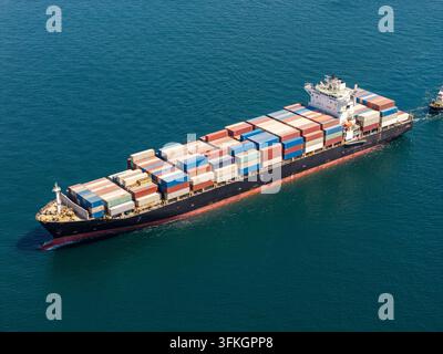 Großes Containerschiff, beladen mit bunten Frachtboxen, segelt über das tiefblaue Meer und symbolisiert globalen Handel, Logistik und internationale Schifffahrt Stockfoto