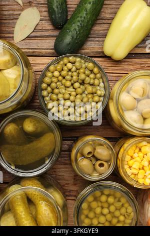 Verschiedene eingelegte Produkte in Gläsern und Zutaten auf Holztablett, Flat Lay Stockfoto
