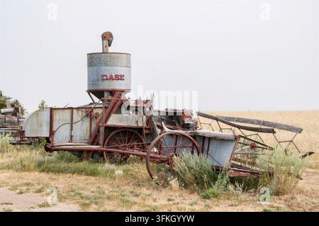 IRRICANA, ROCKY VIEW COUNTY, ALBERTA, KANADA – 08. AUGUST 2026: Eine alte antike Case-Zugmähdrescher, die verlassen auf trockenem Gras neben steht Stockfoto