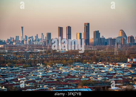 Stadtansicht bei Dämmerung in Peking, mit den Wolkenkratzern Guomao und Wangjing sowie Wohngebieten Stockfoto