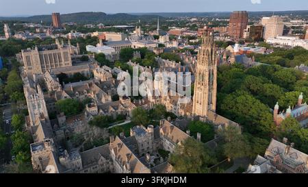 Alter Campusplatz mit Harkness-Turm in New Haven, Connecticut. Luftaufnahme von oben aufsteigend. Sonnenuntergang in einem gepflegten Park der High School Universi Stockfoto