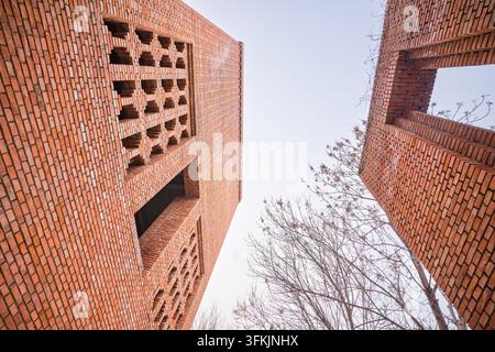 Niedrigwinkelaufnahme von hohlen Ziegelgitterfenstern an der Architektur des Roten Ziegel-Kunstmuseums in Peking Stockfoto