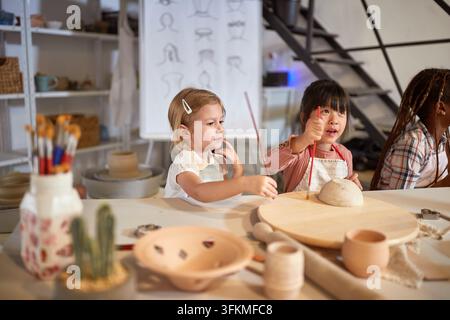 Glückliche Kinder sind kreativ mit Pinseln im Kunstunterricht in der Schule. Kreatives, Hobby, Workshop-Konzept Stockfoto